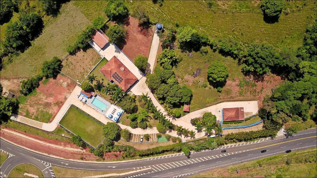 een luchtzicht op een huis op een heuvel met een weg bij Chácara das Araras in Lindóia