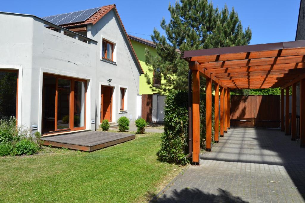 a house with a wooden pergola in a yard at Large house with parking, 30 min to Prague center in Úvaly