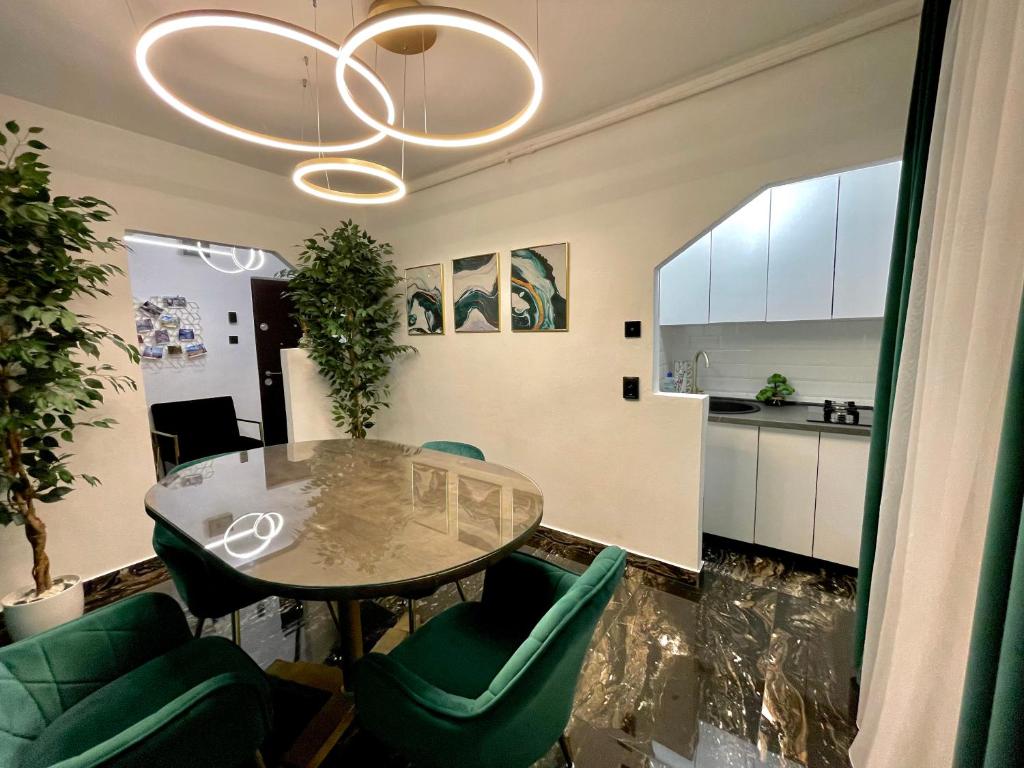 a dining room with a table and green chairs at Golden Valley Apartment in Sibiu