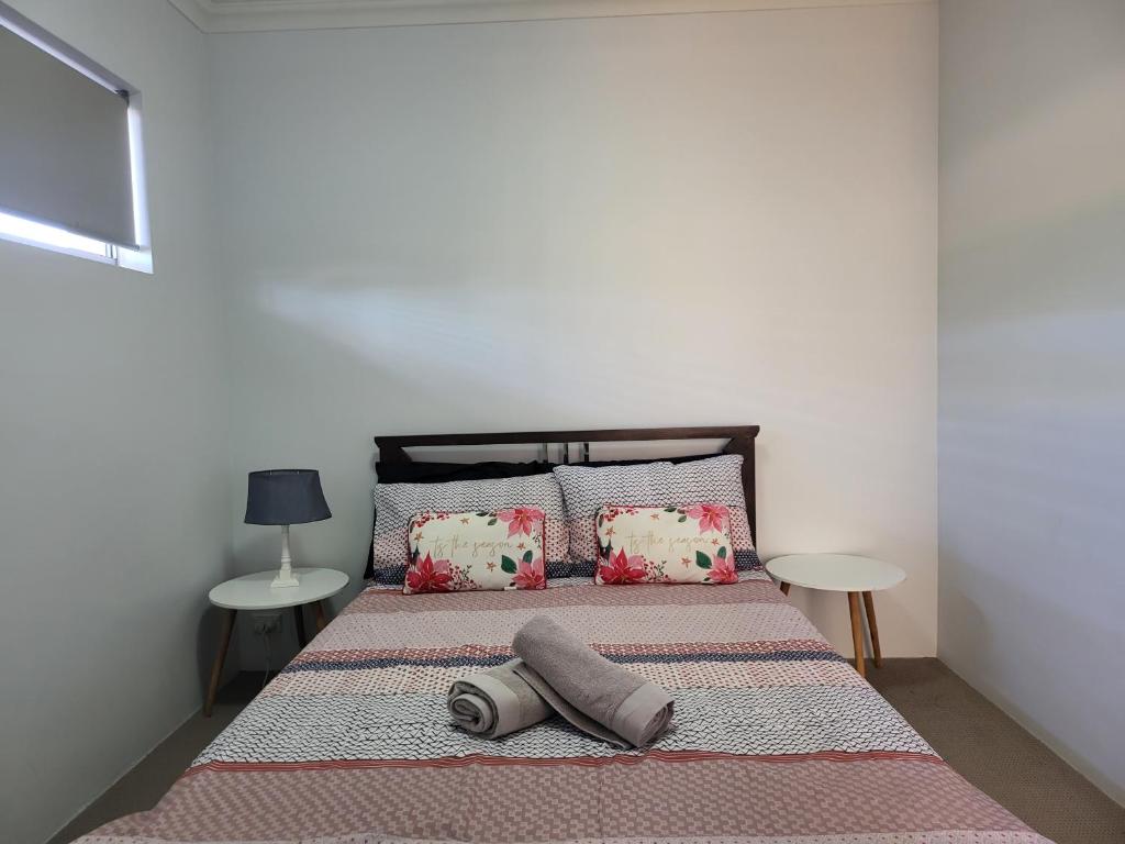 uma cama com duas almofadas e duas mesas num quarto em Gerring Court with Free 1 Car Bay Parking em Perth