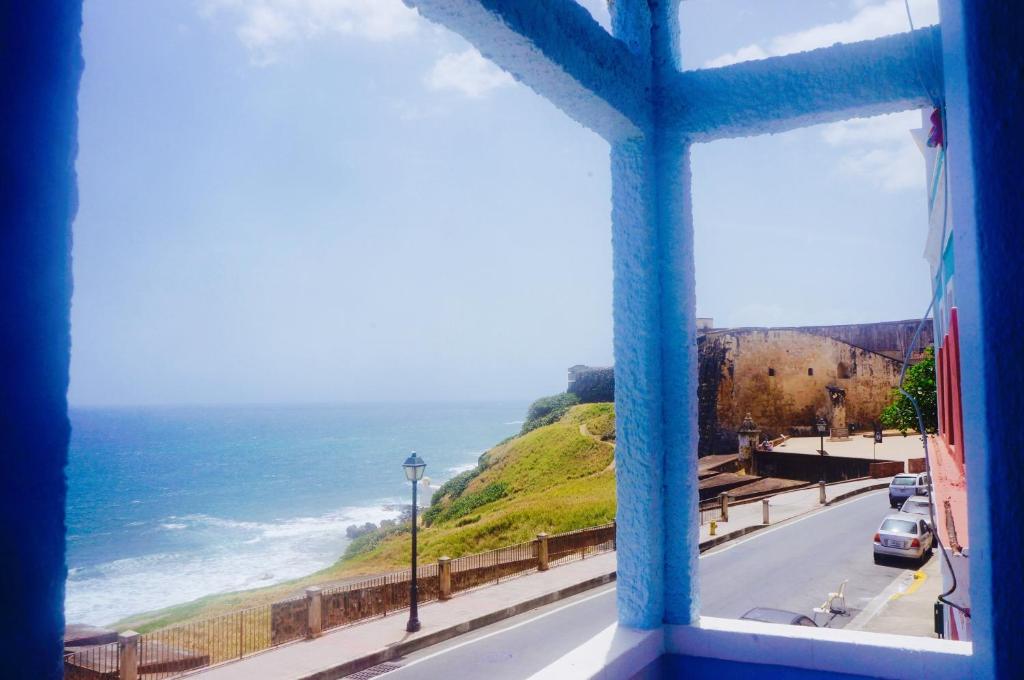 a window with a view of a road and the ocean at La Capitana Old San Juan Building in San Juan