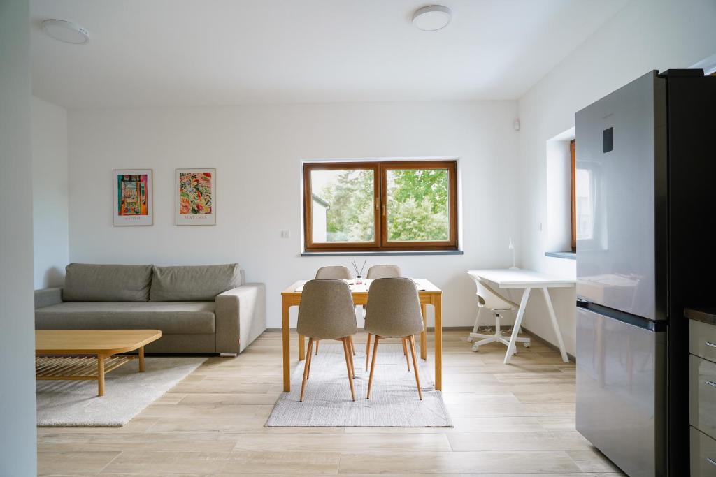 The Dante Villa Apartments في براغ: مطبخ وغرفة معيشة مع طاولة وكراسي