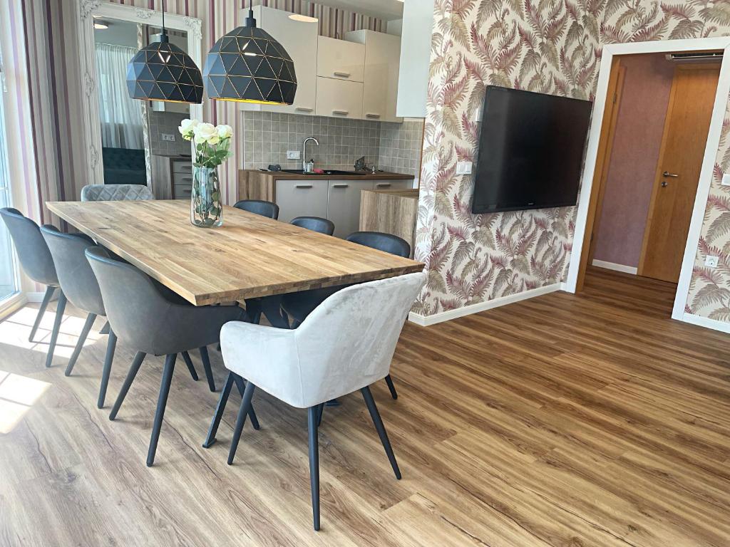 una sala da pranzo con tavolo e sedie in legno di Vila Urbana Luxury Apartments a Lesce
