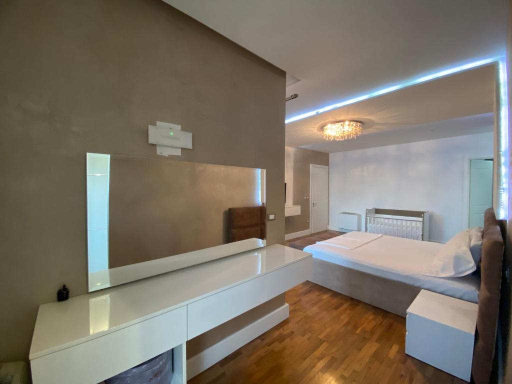 ein Schlafzimmer mit einem Bett und einem großen Spiegel in der Unterkunft Reina Suite in Durrës
