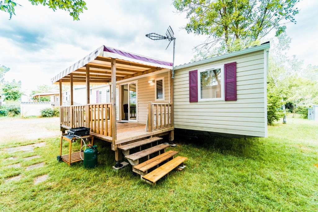 a tiny house on the grass in a yard at Mobil-home 6/8 personnes - Camping Siblu **** Domaine de Dugny in Onzain