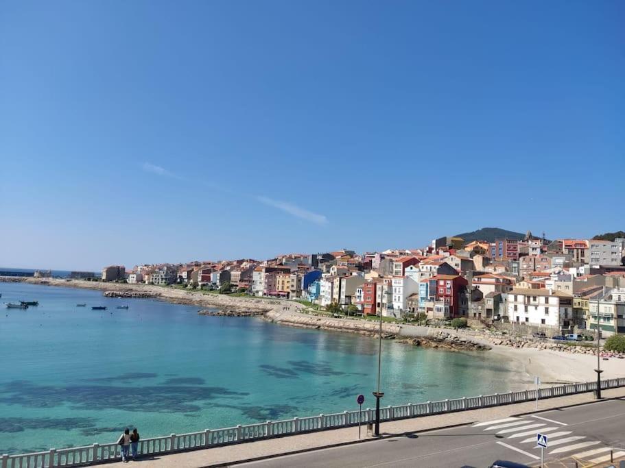 - une vue sur la ville et une étendue d'eau dans l'établissement Acogedor piso en primera línea de mar- 8 huéspedes, à A Guarda