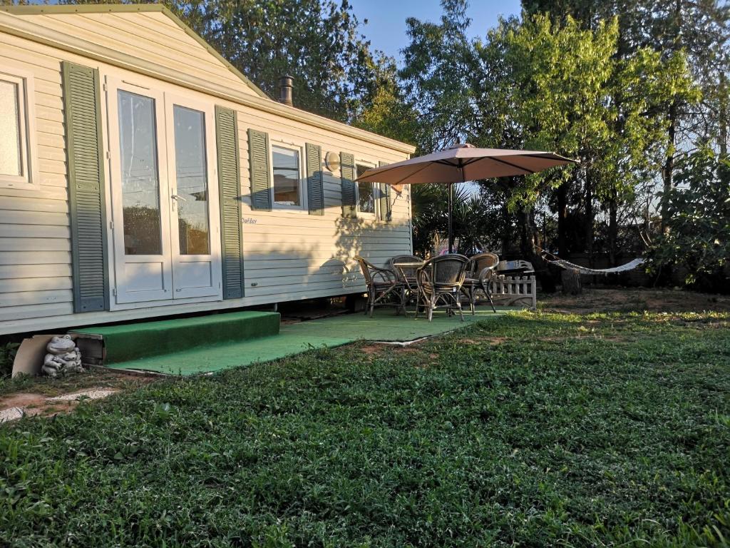 Casa con patio con sombrilla y sillas en Casa Venus - con jardín y piscina, en Alcalá de Guadaira