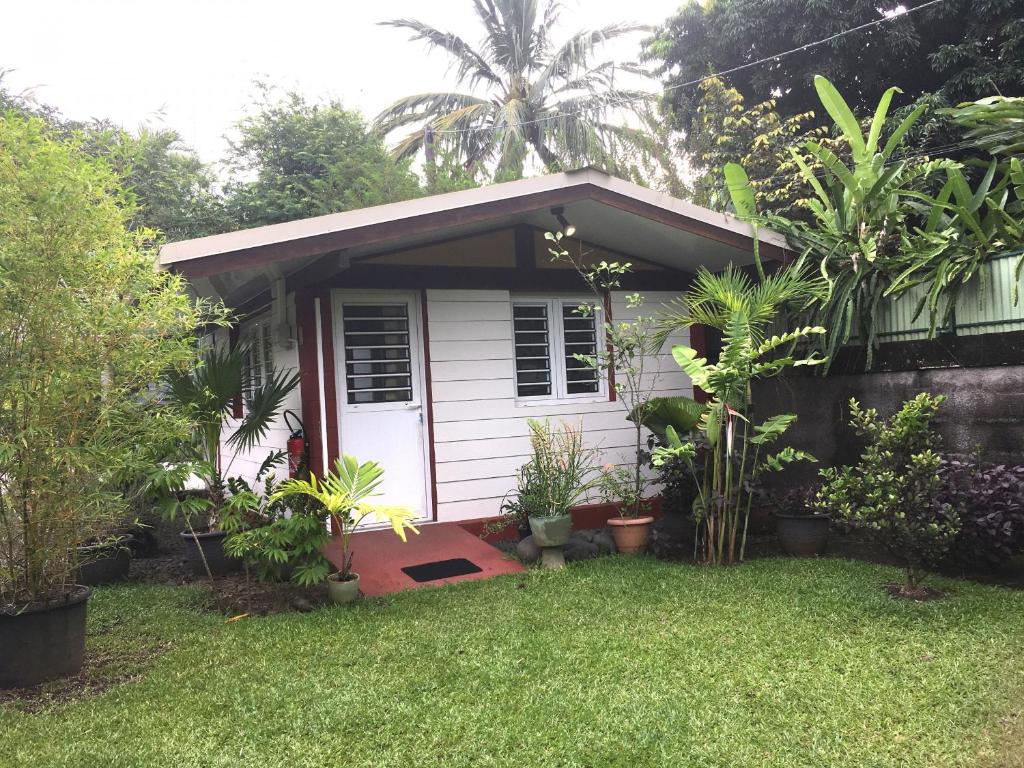 uma pequena casa branca com plantas no quintal em TAHITI - Bungalow Honey Moon em Pirae