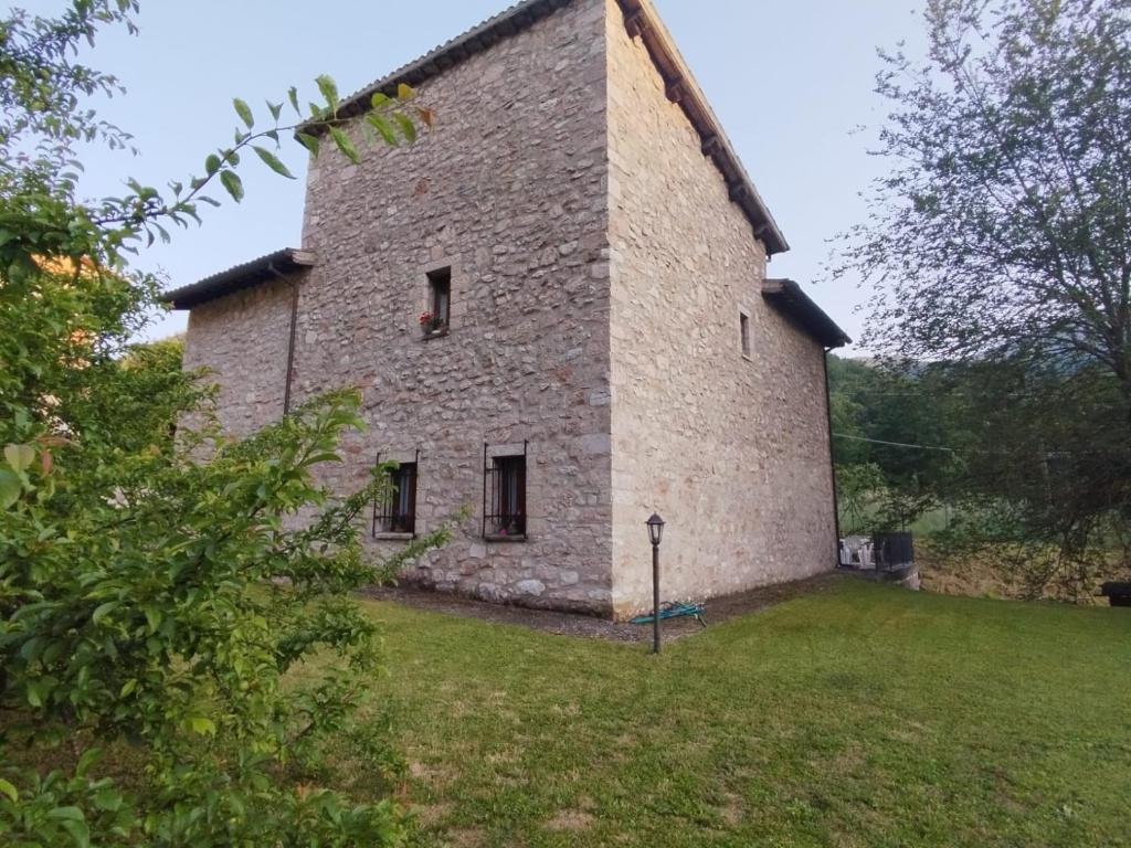 een groot stenen gebouw met een grasveld bij La Casa Dei Fagiani in Foligno