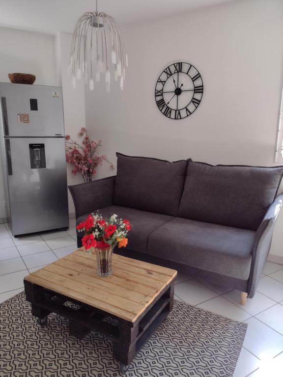 uma sala de estar com um sofá e uma mesa com flores em Bienvenue dans beau T2 de 48m2 à Gennevilliers em Gennevilliers