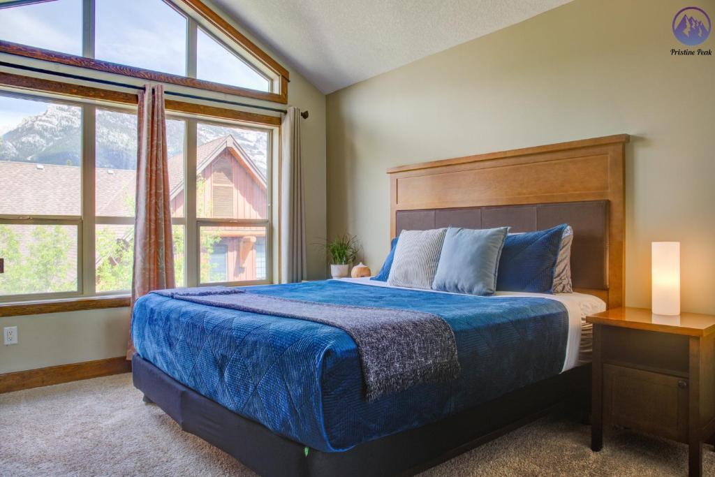 a bedroom with a bed and a large window at Fire Mountain Two Bedroom Condo in Canmore