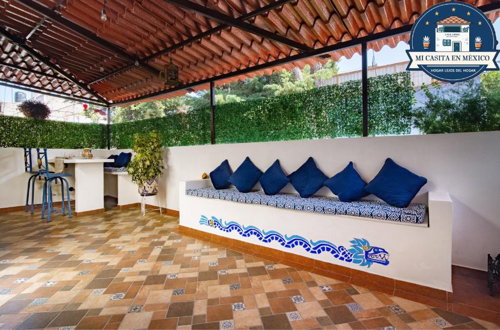 una habitación con un banco con almohadas azules en Ursus, Mi casita en México en Ciudad de México