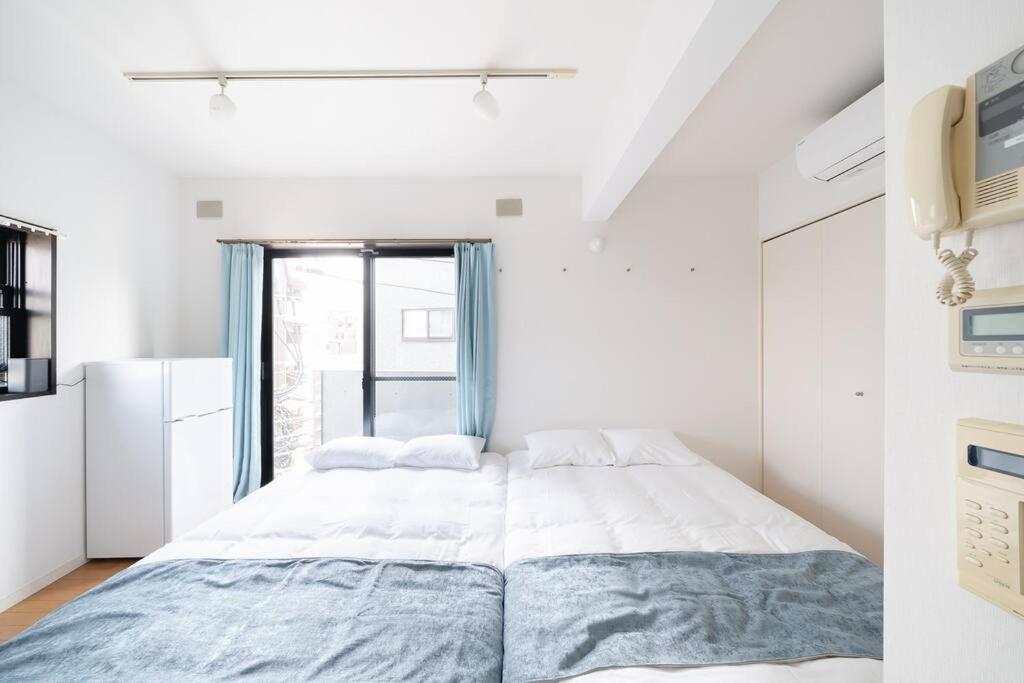 - une chambre avec un grand lit et une fenêtre dans l'établissement Granduo 松濤, à Tokyo