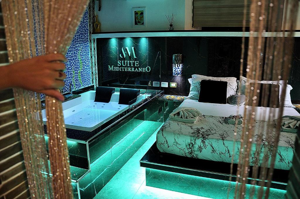 a room with a bed and a tub in it at Suite Mediterraneo in Civitavecchia