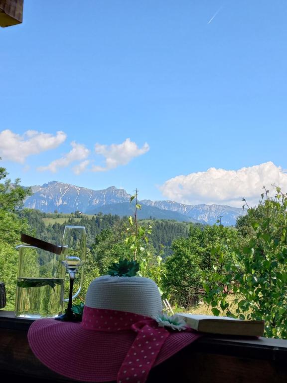 a hat sitting on a table with a view of mountains at The Sun Chalet by Touch the Sky in Moieciu de Jos