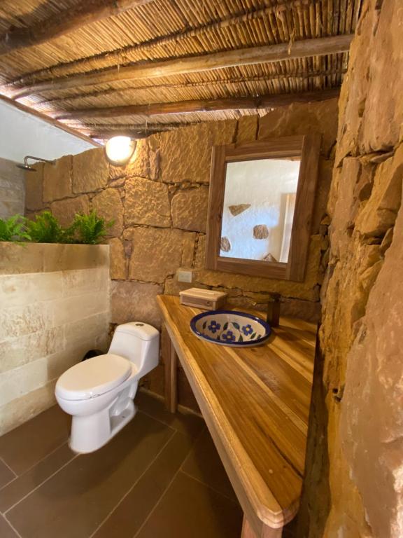 a bathroom with a toilet and a wooden counter at El Principito Hospedaje in Barichara