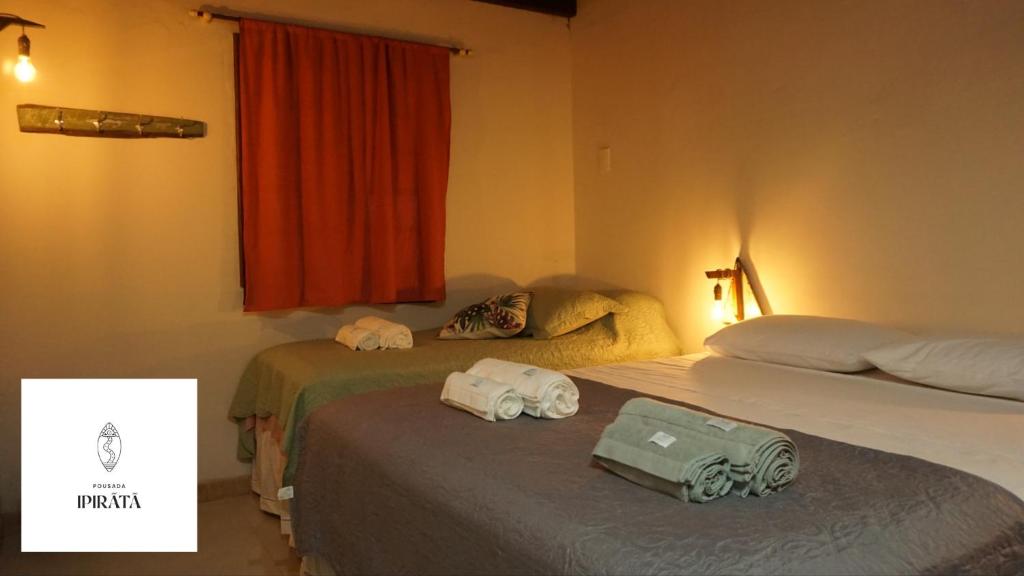 Dos camas en una habitación de hotel con dos bolsas. en POUSADA IPIRÃTÃ - Turismo de Vivência Cultural, en Soure