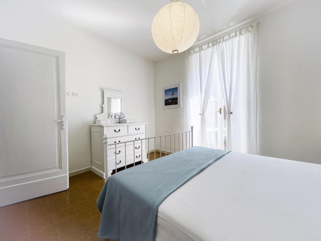 a white bedroom with a bed and a dresser at BLUE HOUSE - incantevole casa a due passi dal mare in Grottammare