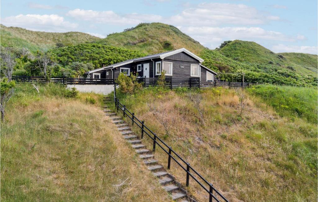 una casa en una colina con un conjunto de escaleras en Amazing Home In Blokhus With House Sea View, en Blokhus