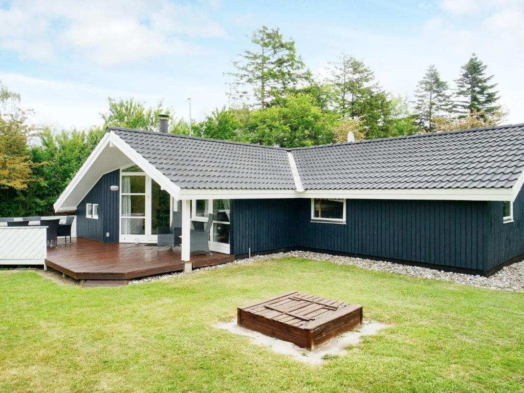 ein Haus mit einem großen Garten mit einer Terrasse in der Unterkunft Four-Bedroom Holiday home in Slagelse 2 in Store Kongsmark