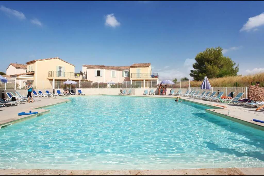 einen großen Pool mit blauem Wasser und Stühlen in der Unterkunft Villa Marsihla in Cabriès