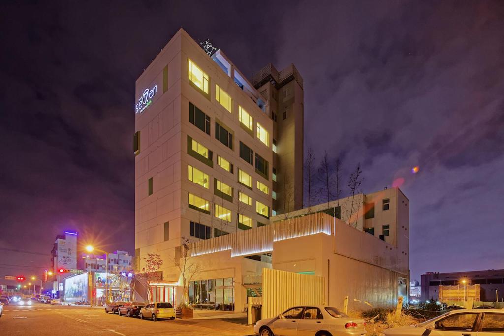 a tall building with cars parked in a parking lot at Hotel 7 Taichung in Taichung