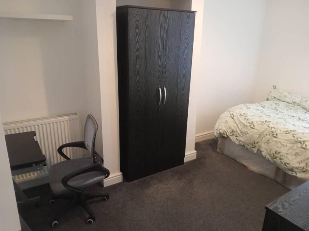 バーンリーにあるDouble-bed (G4) close to Burnley city centreの黒いキャビネット、デスク、椅子が備わる客室です。