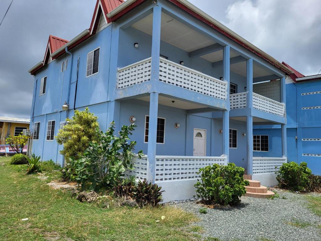 a blue building with a white balcony at OceanView Villa in Buccoo