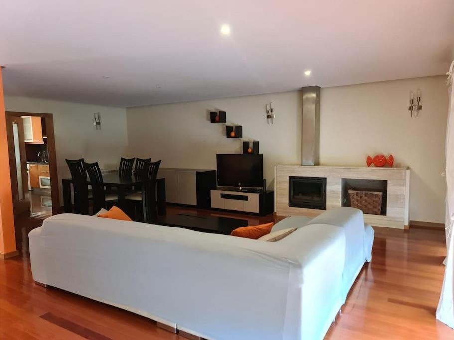 ein Wohnzimmer mit einer weißen Couch und einem Kamin in der Unterkunft Arcos de Valdevez, Recanto da Prova - PNPG in Arcos de Valdevez