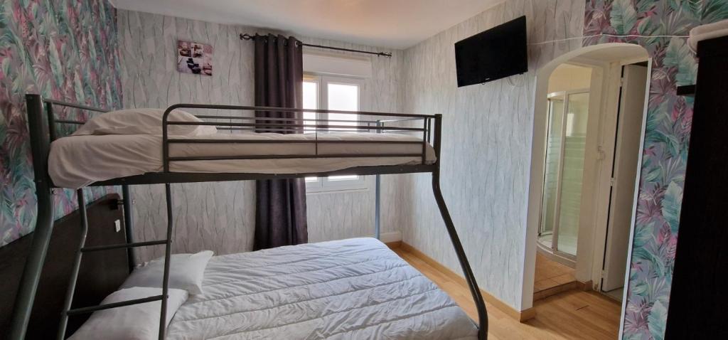 a small bedroom with a bunk bed and a mirror at Hotel Les Rosiers in La Rochelle