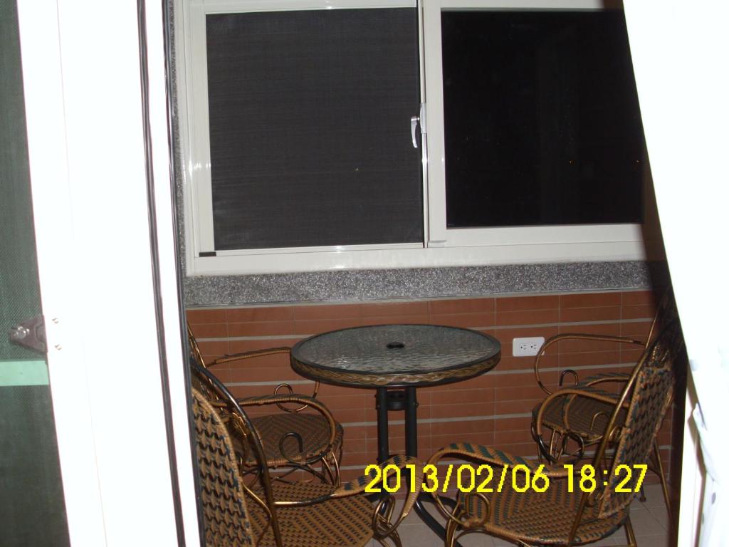 a table and chairs in front of a window at Xinchuan B&amp;B in Dayi