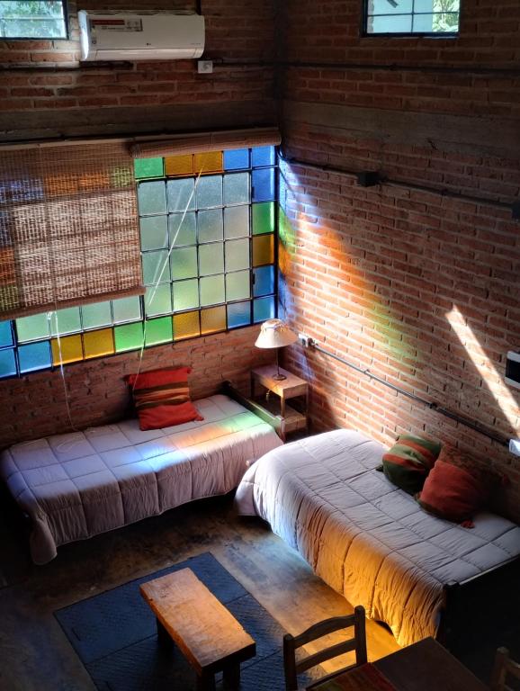 um quarto com 2 camas e um vitral em Loft El Taller - Rústico, elegante, acogedor em Yerba Buena