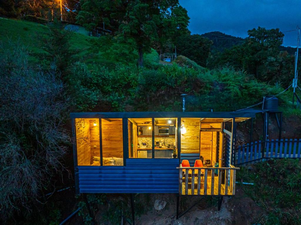 a blue tiny house on a hill at night at Tiny House Jaulares in Rivas