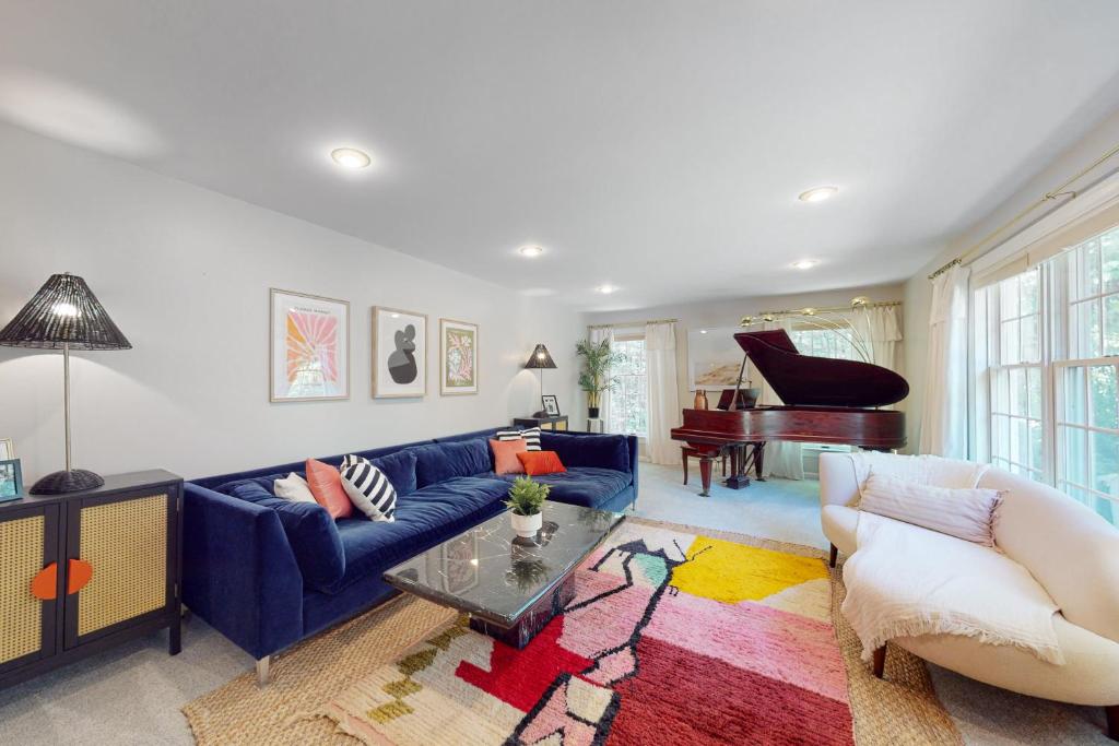 sala de estar con sofá azul y piano en Meadowhawk Haven, en Bath