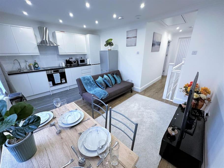 a kitchen and living room with a table and a couch at (ZONE 2) STYLISH 2 BED FLAT IN THE HEART OF LEWISHAM in London