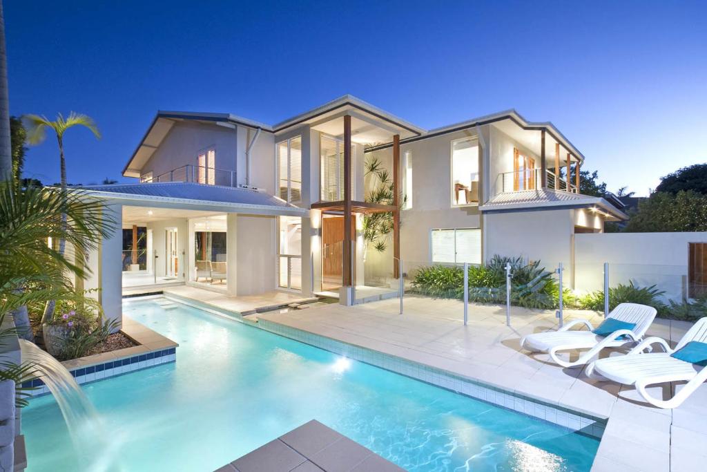 a house with a swimming pool in front of it at 20 Wesley Court, Noosa Heads in Noosa Heads