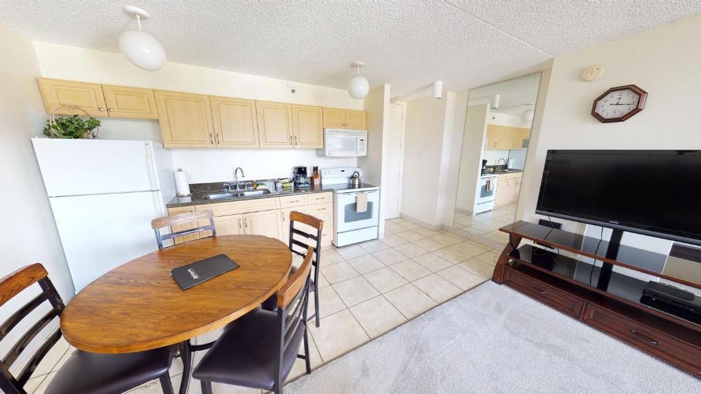 cocina y comedor con mesa y TV en One-Bedroom Apartment, en Honolulu
