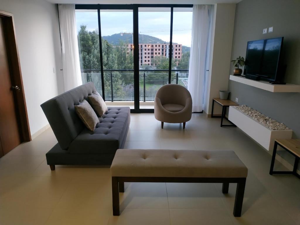 - un salon avec un canapé, une chaise et une télévision dans l'établissement Apartamento Zipa 301, à Paipa