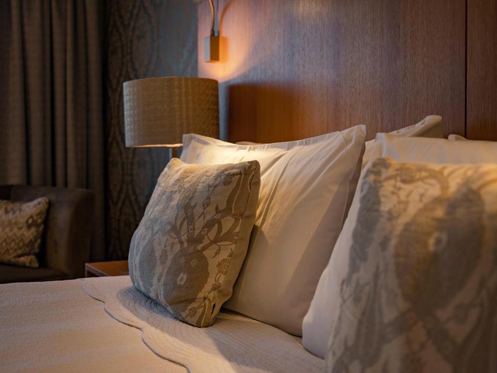 una camera d'albergo con letto con cuscini e lampada di Porters Boutique Hotel a Havelock North