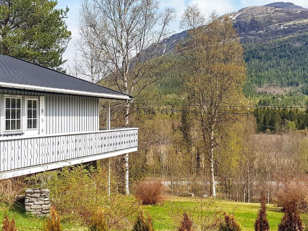 a white house with a mountain in the background at Holiday home Tynset in Tynset