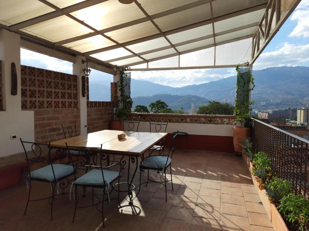 einen Tisch und Stühle auf einer Terrasse mit Aussicht in der Unterkunft Villa del Prado in Medellín