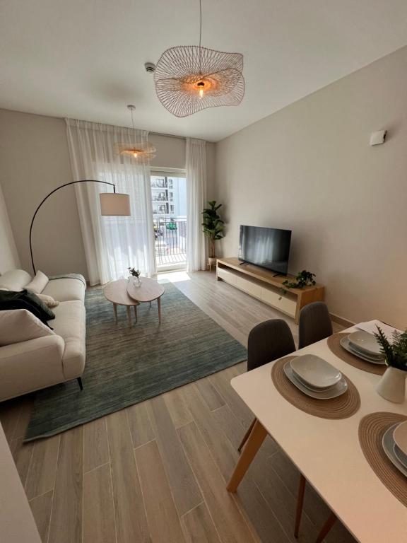 ein Wohnzimmer mit einem Sofa und einem TV in der Unterkunft Waters edge in Abu Dhabi
