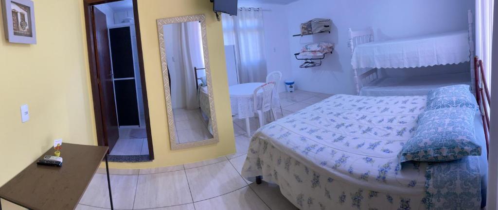 1 dormitorio con cama y espejo en Pousada Cirandinha Apart Hotel, en Itajaí