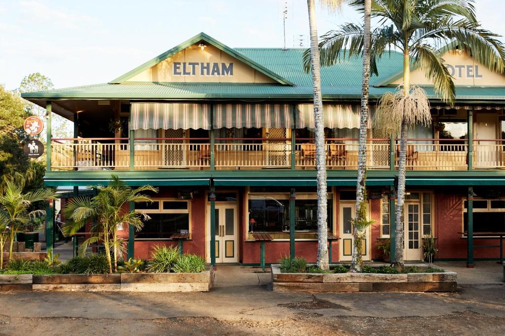un edificio con palmeras delante en Eltham Hotel NSW, en Eltham