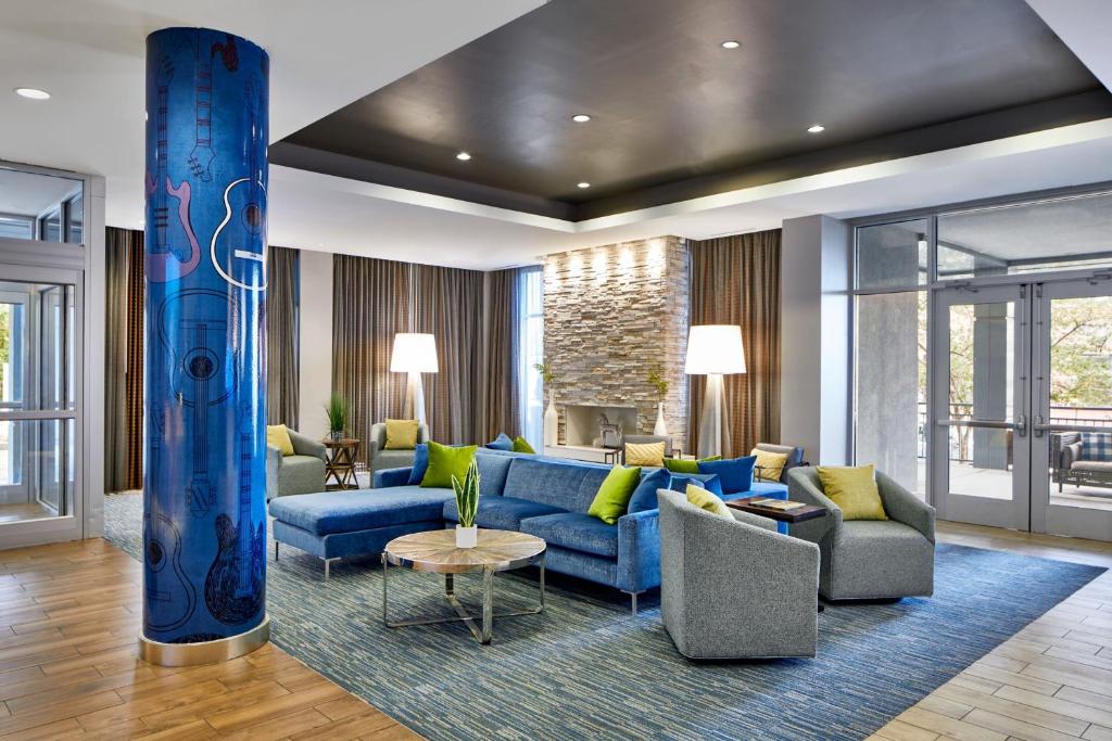 uma sala de estar com um sofá azul e cadeiras em Fairfield Inn and Suites by Marriott Nashville Downtown/The Gulch em Nashville