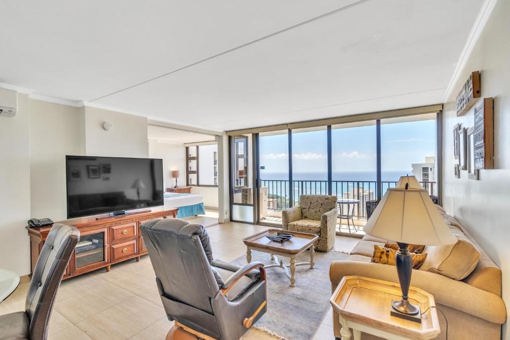 uma sala de estar com um sofá e uma televisão em 37th Floor Condo with Sweeping Ocean Views & Free parking! condo em Honolulu