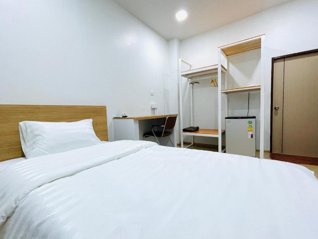 1 dormitorio con 1 cama blanca grande y escritorio en PD Apartment Inn, en Ban Pra Dok