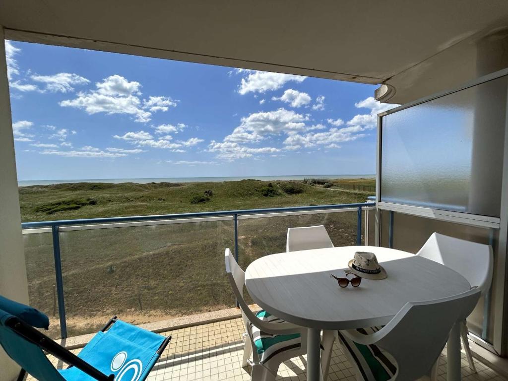 une table blanche et des chaises sur un balcon avec vue dans l'établissement Appartement cosy avec balcon face mer - Accès plage & parking privé - FR-1-224C-241, à Saint-Jean-de-Monts