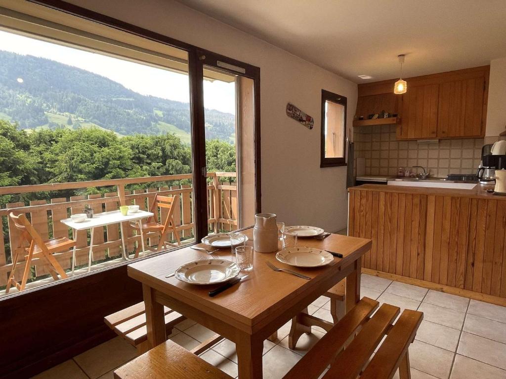 een keuken met een tafel en een groot raam bij Appartement Praz-sur-Arly, 1 pièce, 5 personnes - FR-1-603-79 in Praz-sur-Arly