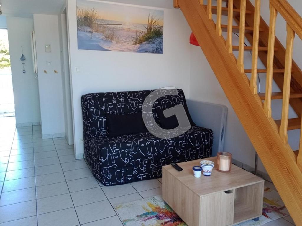 a living room with a chair and a staircase at Appartement La Tranche-sur-Mer, 3 pièces, 5 personnes - FR-1-357-309 in La Tranche-sur-Mer